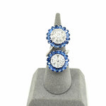 Sapphire and diamond double spinwheel ring in 18K white gold on a ring display