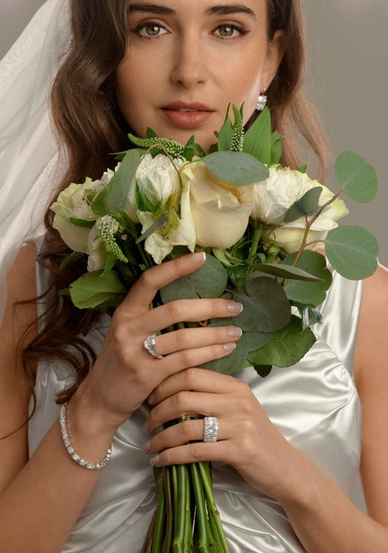 Bride holding a bouquet and wearing a diamond engagement ring and wedding band