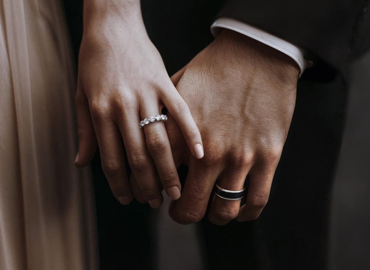 A couple holding hands wearing wedding bands