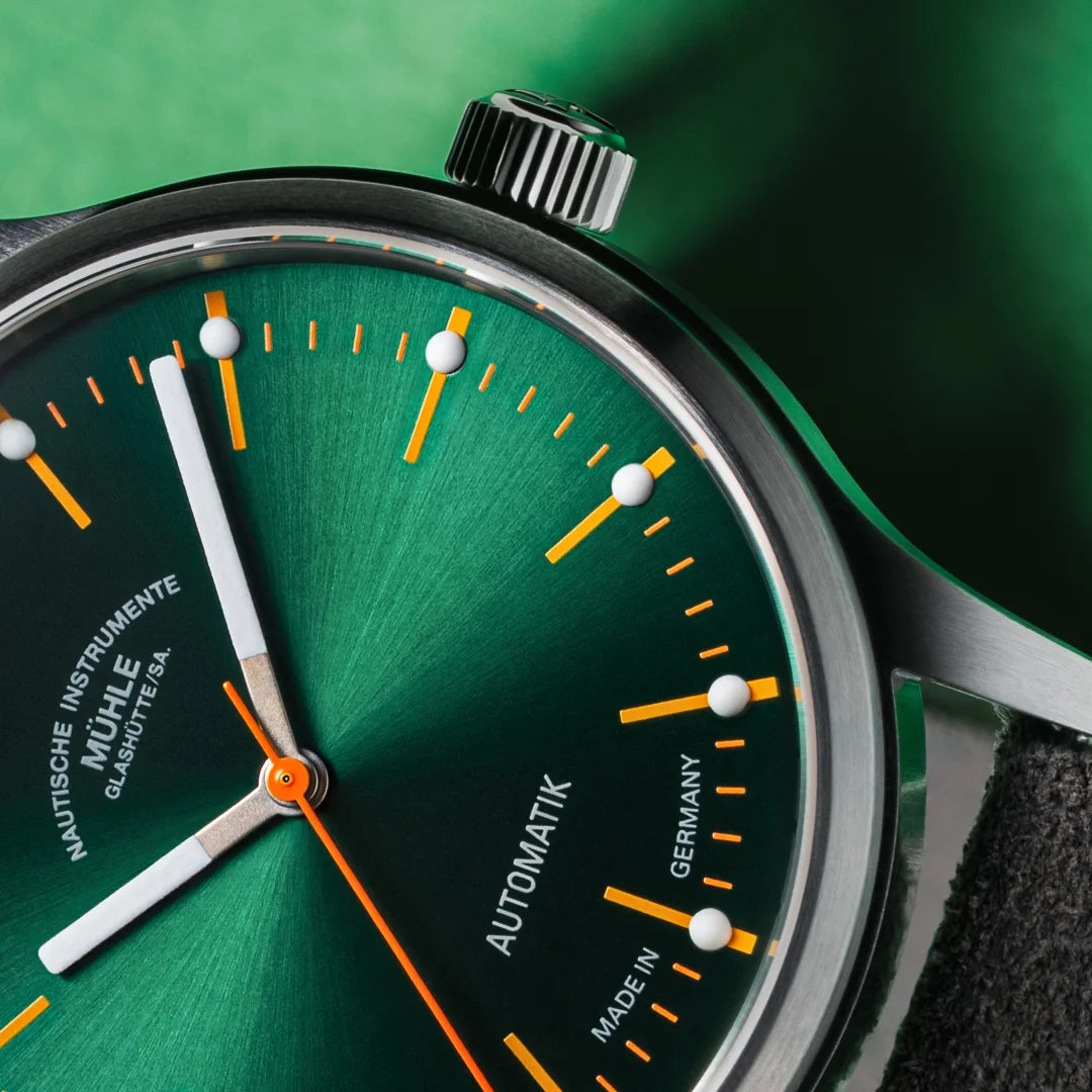Mühle-Glashütte Panova Green dial close-up with orange accents and luminous hour markers