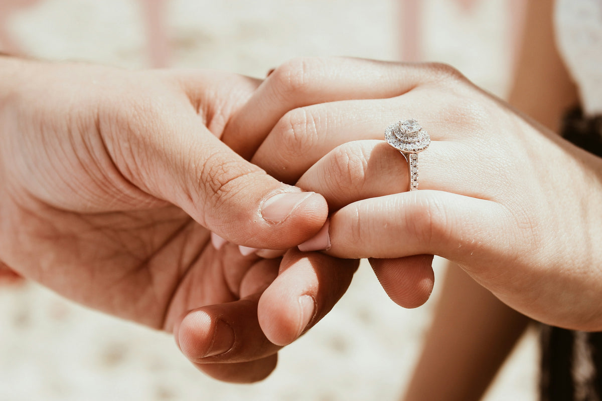 Placing a diamond engagement ring on her finger
